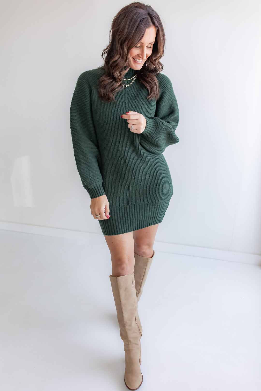 Hunter green turtleneck sweater dress for women paired with tall boots