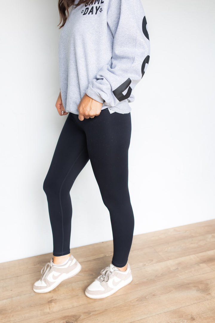 Side profile of black contour leggings with sneakers