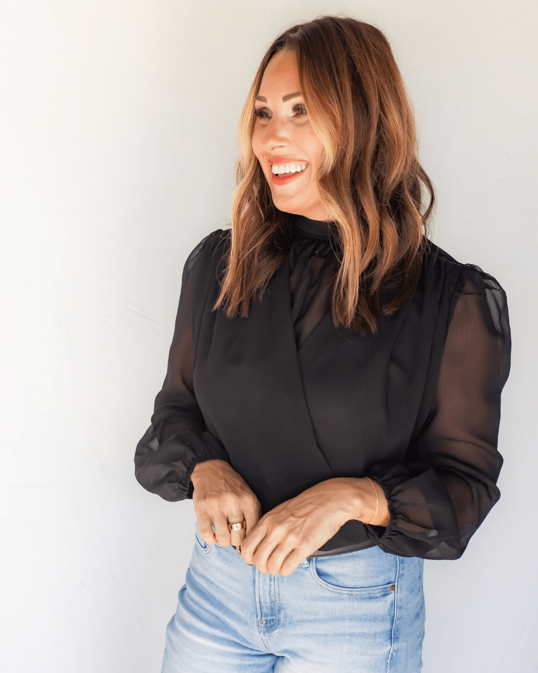 Close-up of black chiffon blouse with gathered high neckline and non-sheer surplice front