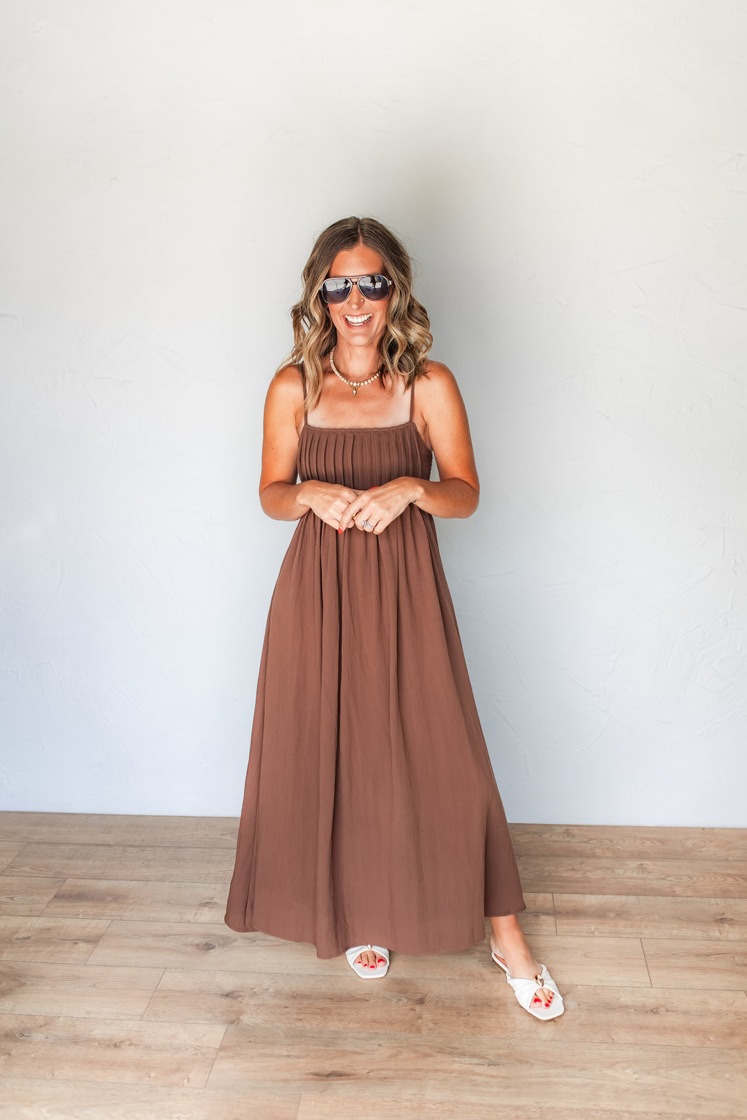 Woman wearing chocolate brown pintuck maxi dress with white sandals