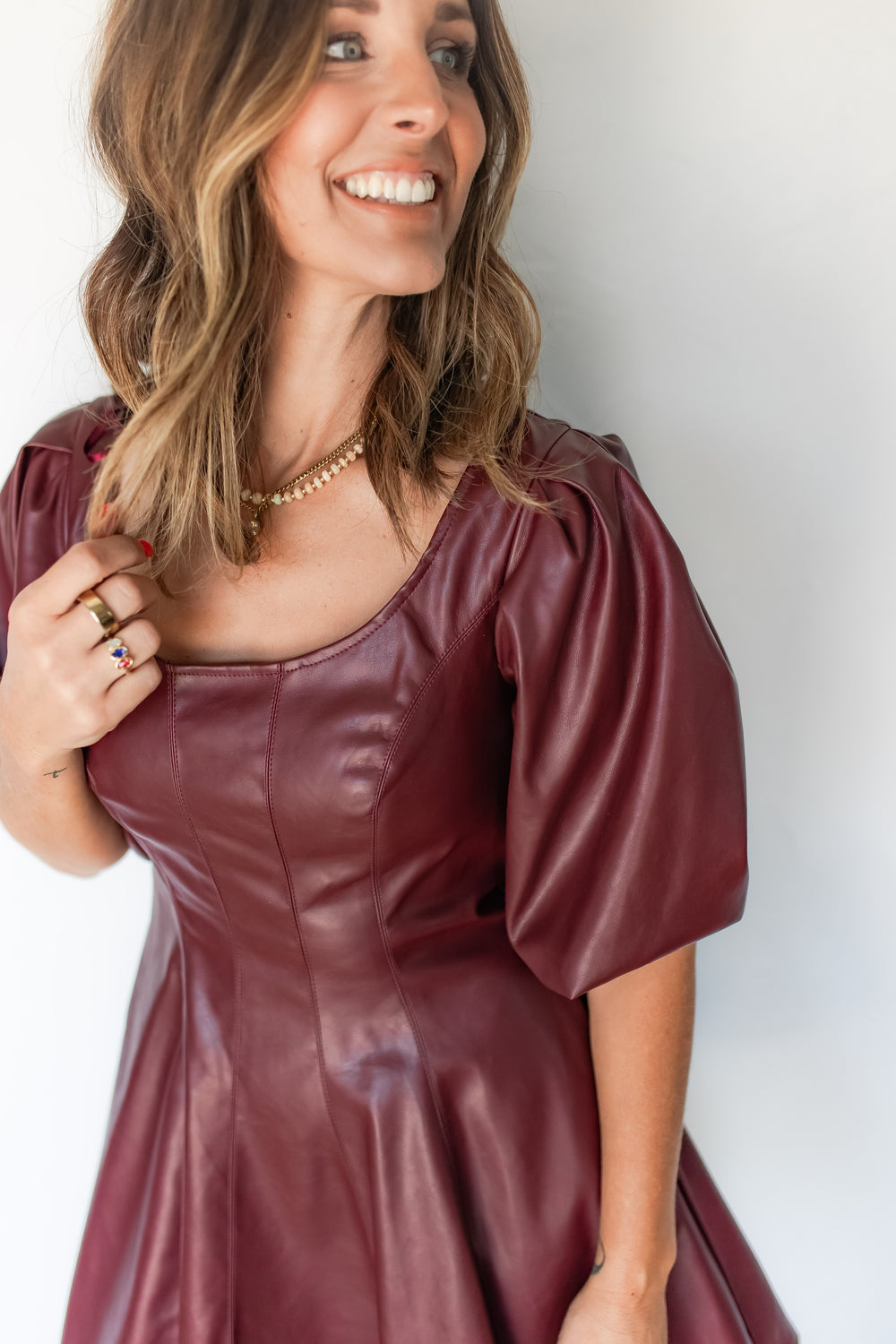 Close-up of burgundy faux leather dress front neck and seaming detail
