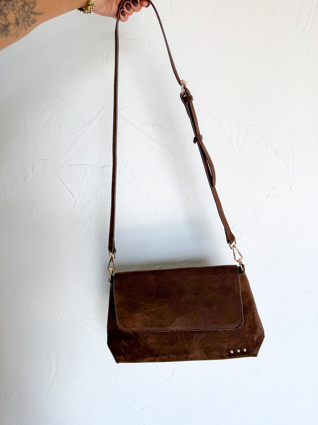 Chocolate brown suede crossbody bag with magnetic flap closure and adjustable strap