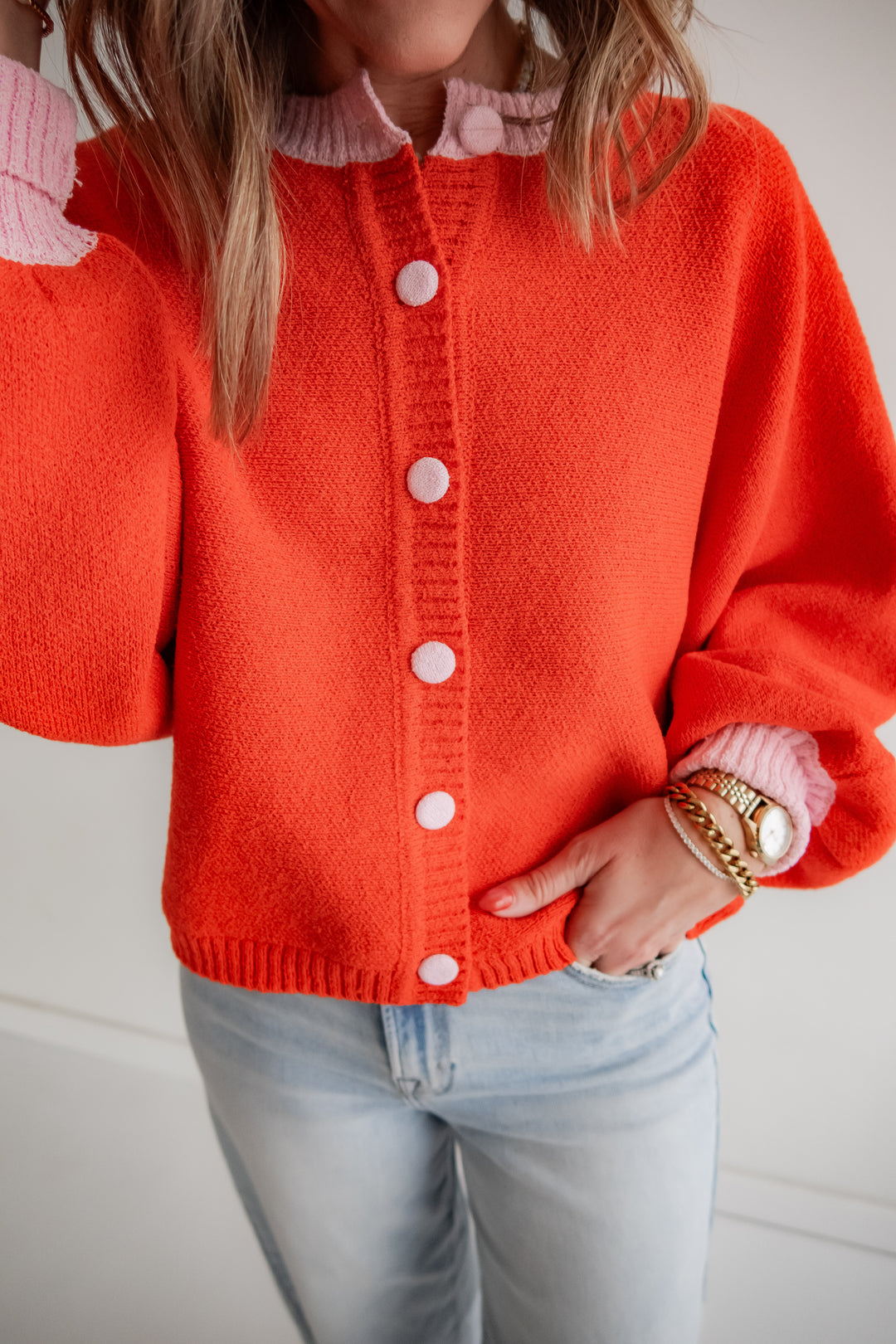 Coral cardigan with light pink trim and buttons