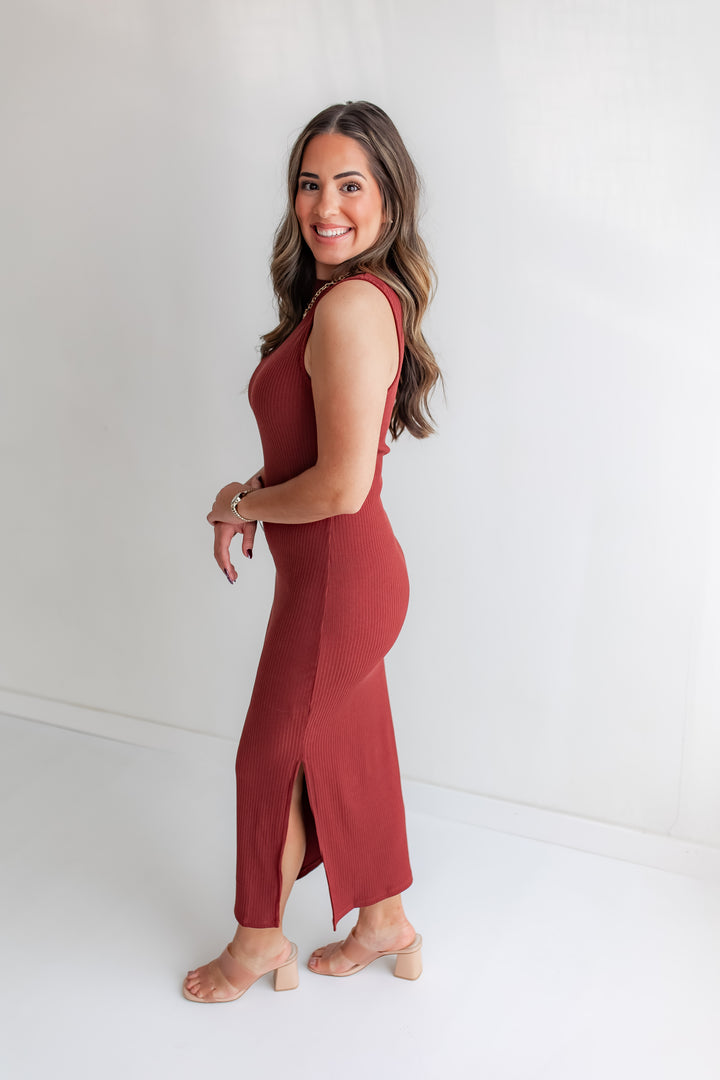 Woman wearing a rust color midi dress against a white background