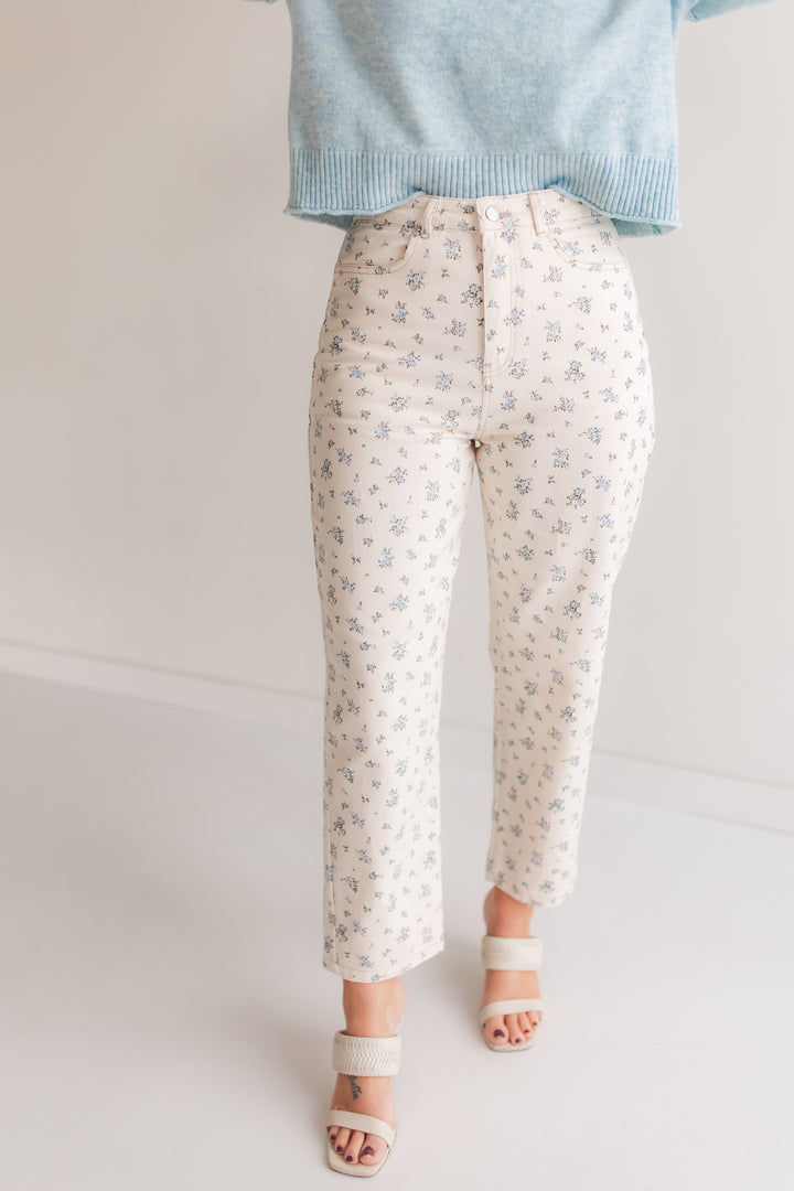 Woman wearing floral high rise straight leg jeans styled with a sweater for a spring outfit