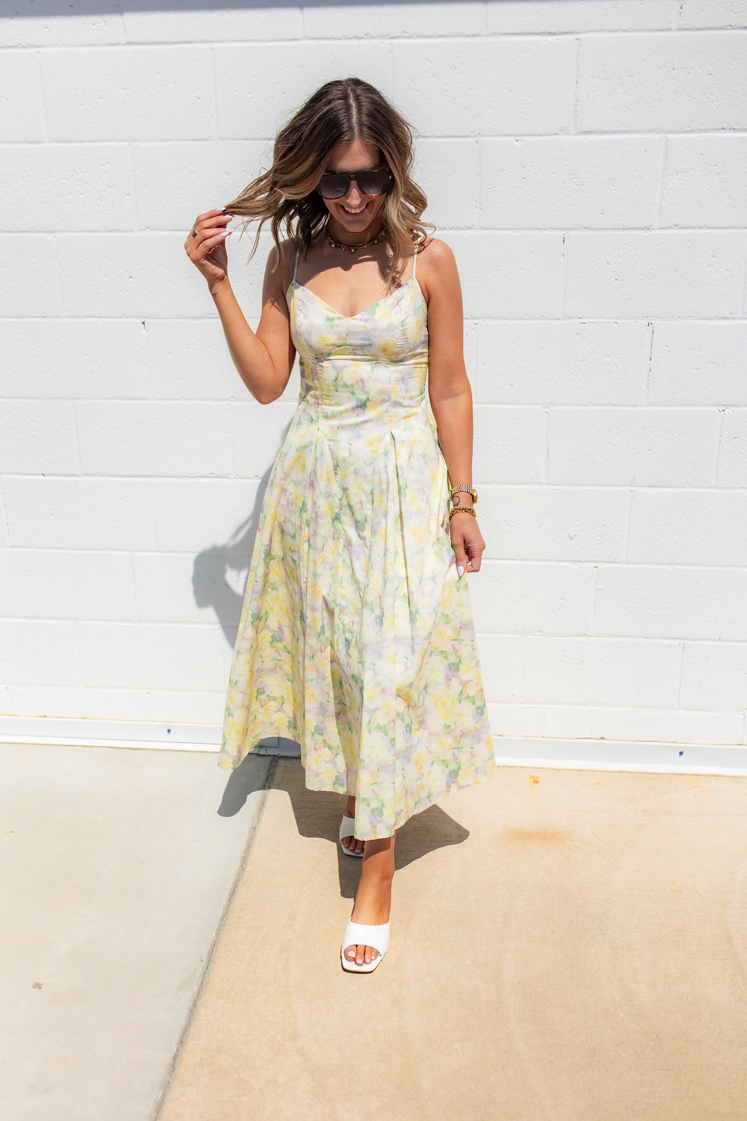 Floral midi dress with soft pastel print and flowy skirt styled for a spring wedding or event