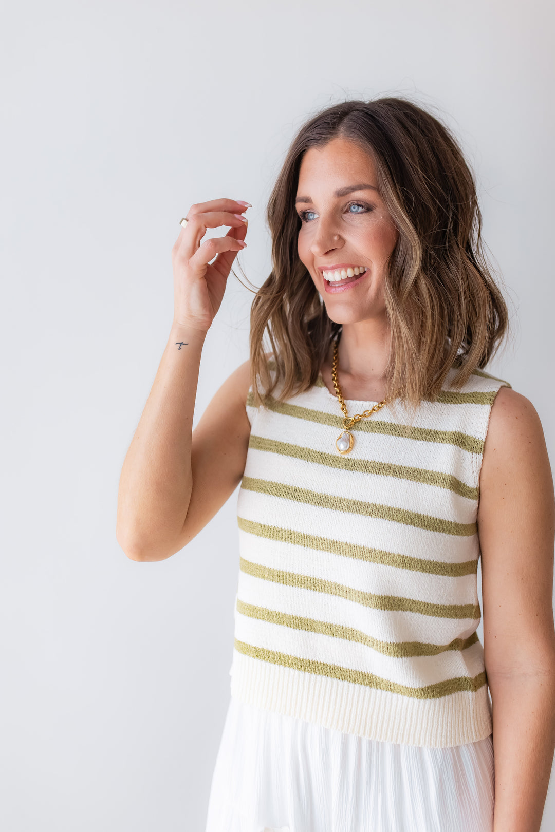 Green striped sleeveless knit top with tie back detail styled with white maxi skirt for spring outfit