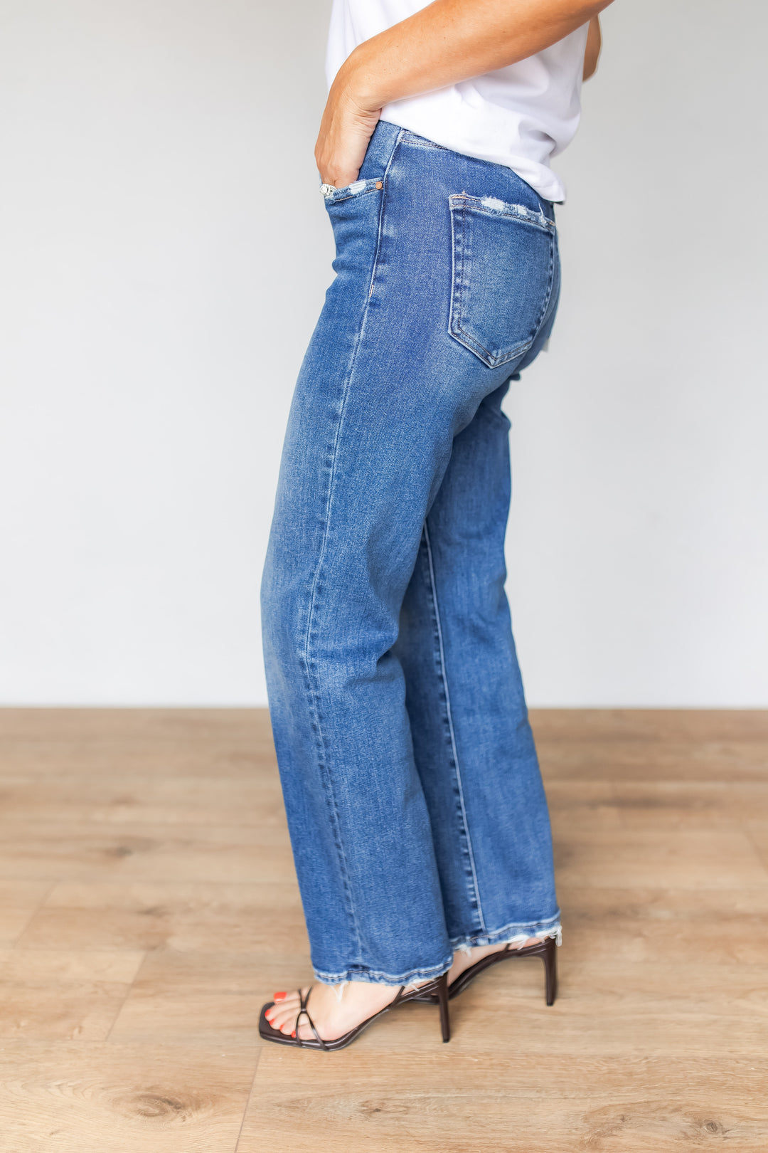 Side view of medium wash straight leg jeans back pocket detail