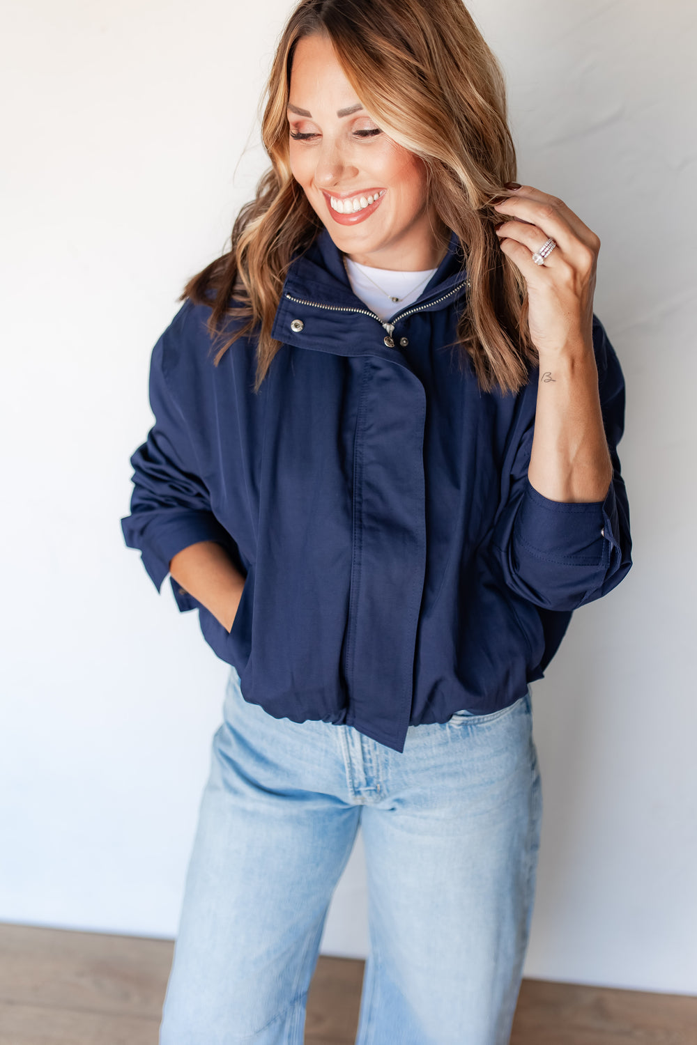 Close-up of navy jacket snap collar and silver zipper detail