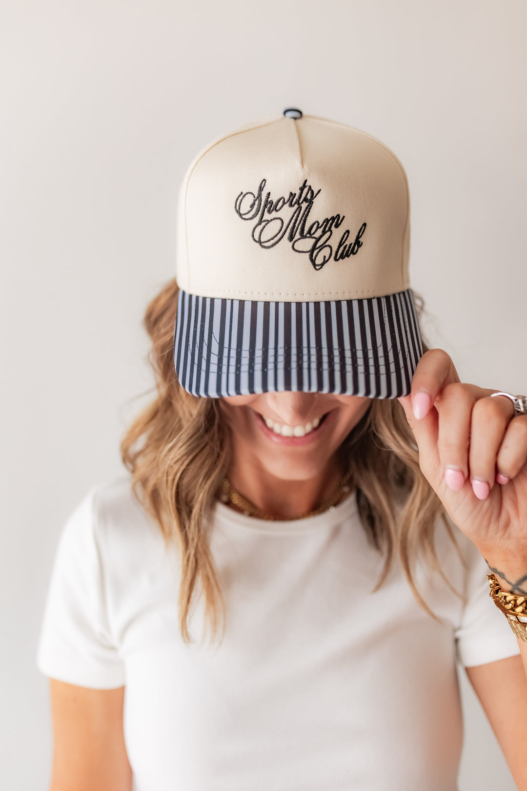 Women’s navy stripe trucker hat with sports mom club themed embroidery and striped bill styled casually