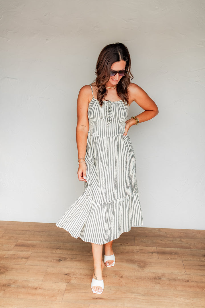 Striped midi dress with smocked bodice and flowy skirt styled for summer wear