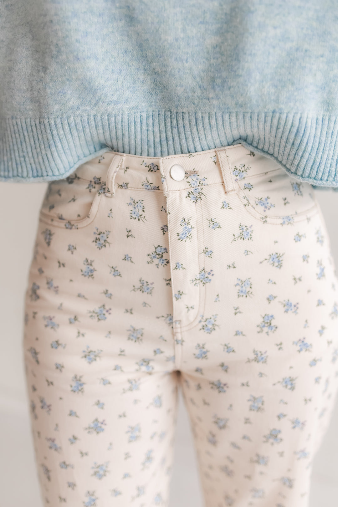 Close up of blue floral print on high rise white denim jeans
