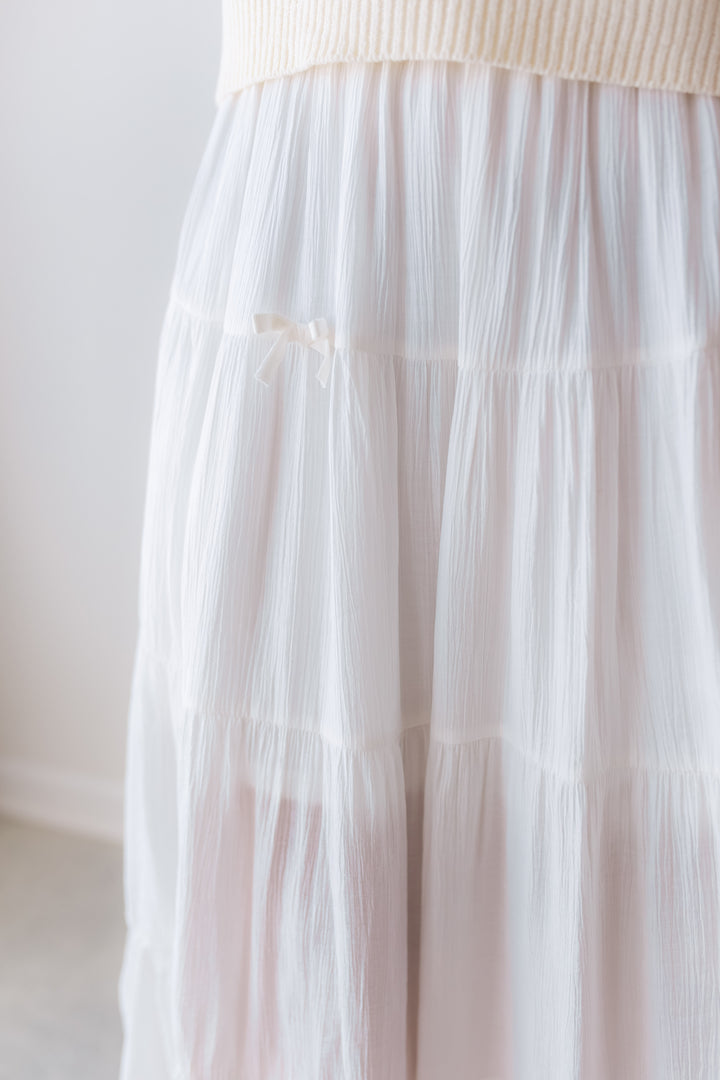 Close up of white maxi skirt with small bows