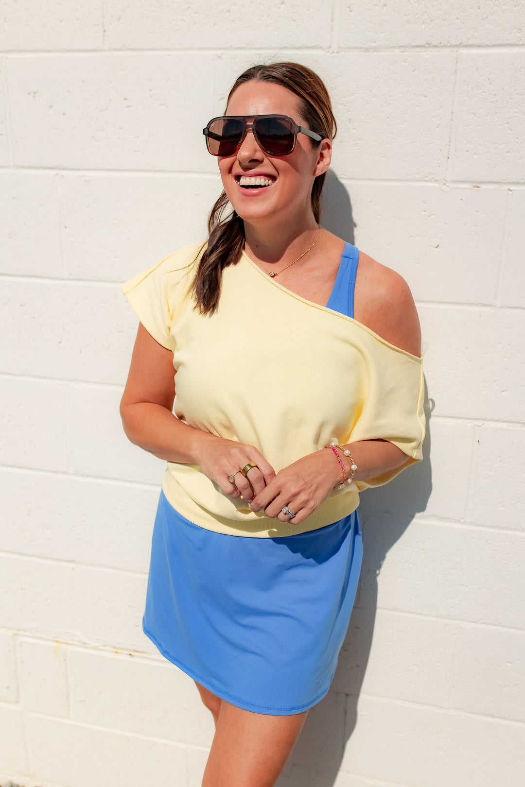 Yellow off shoulder top styled with a blue active dress for a casual everyday outfit