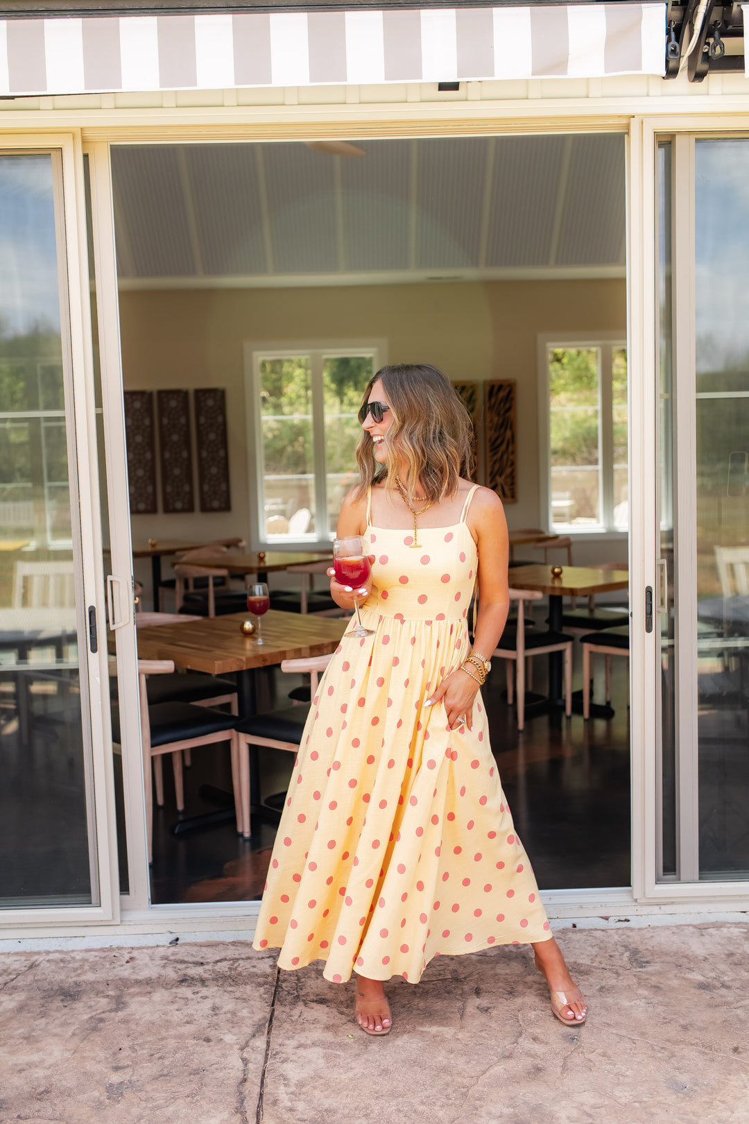 Yellow polka dot maxi dress styled for a summer event or vacation outfit